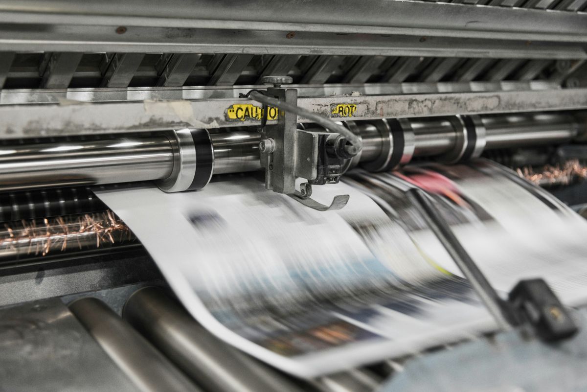 Newspapers running through a printing press